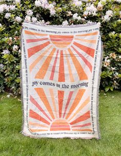 an orange and white quilt with the words joy comes in the morning