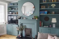 a living room filled with furniture and a fire place in front of a tv mounted on a wall