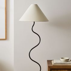 a lamp that is on top of a table next to a bowl and bookcase