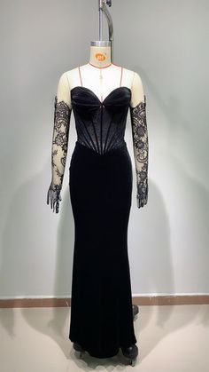 a mannequin wearing a black dress with lace sleeves