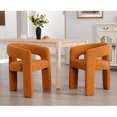 two orange chairs sitting in front of a table