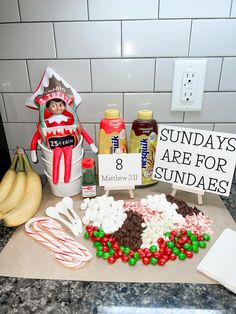 a kitchen counter topped with lots of candy and candies next to a sign that says sunday are for sundaes