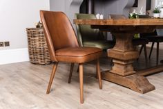 a wooden table with two chairs and a basket on the floor in front of it