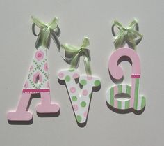 three wooden letters decorated with bows and polka dots, each letter shaped like a child's name