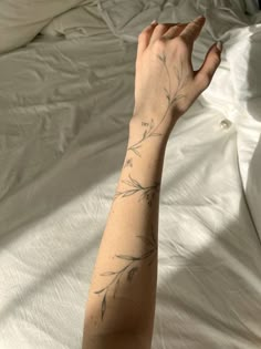 a person's arm with a tattoo on it, in front of a bed