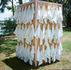 a wooden structure made out of cloths in the grass