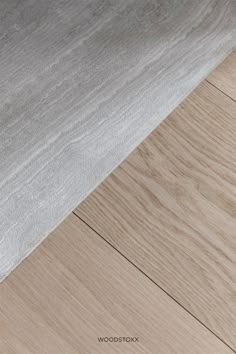 a close up view of a wood floor with white and grey colors on the surface