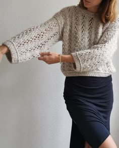 a woman in a skirt is wearing a sweater