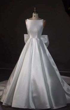 a white wedding dress on display in front of a mannequin