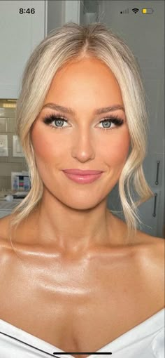 a woman with blonde hair and blue eyes posing for a photo in front of a mirror