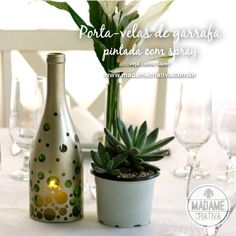 a table topped with a vase filled with flowers next to a bottle and wine glasses