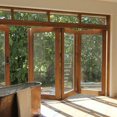 an empty bathroom with sliding glass doors leading to the outside patio and trees in the background