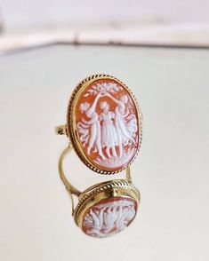 "The Three Graces adjustable cameo rings are finally here!! Featuring a beautiful, elegant cameo ring framed with a textured golden silver sterling band. Ring is easily adjustable to fit any adult size. The golden silver band is completely irritation and allergy free, silver sterling 925. Perfect gift for mothers day, anniversary, bridal jewelry, wedding jewelry. The Three Graces are known to represent youth, beauty, mirth, and elegance. each cameo is made by hand, carved from sea shell, followi Elegant Wedding Signet Ring With Intaglio, Victorian Cabochon Wedding Rings, Elegant Engraved Intaglio Ring For Gift, Elegant Cameo Engraved Ring As Gift, Elegant Cameo Engraved Ring For Gift, Elegant Engraved Cameo Ring For Gift, Elegant Wedding Cameo Signet Ring, Yellow Gold Cameo Rings For Gifts, Yellow Gold Cameo Jewelry For Wedding