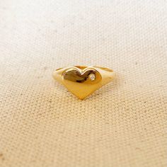 A cute heart with cubic zirconia accent to shiny your soul. 18k Gold Filled ring featuring a heart shaped polished top with a single micro pave Cubic Zirconia Stone. * Metal: 18k Gold Filled * Weights 1.0 grams * Hypoallergenic jewelry * Handcrafted in Brazil Learn how to care for your jewelry with these easy instructions. Properly handling and caring for your ArtBossa jewelry is essential in maintaining its pristine condition. 1. Keep your gold-filled jewelry away from chemicals and cleaning pr Heart-shaped Single Diamond Jewelry For Promise, Gold Diamond Heart Ring For Valentine's Day, Heart-shaped Single Diamond Promise Ring, Yellow Gold Heart Ring With Cubic Zirconia, Gold Heart Cut Cubic Zirconia Heart Ring, Valentine's Day Yellow Gold Heart Ring With Cubic Zirconia, Gold Heart Ring With Single Diamond In 14k Gold, Dainty Gold Diamond Heart Ring, Minimalist Diamond Heart Ring As Gift