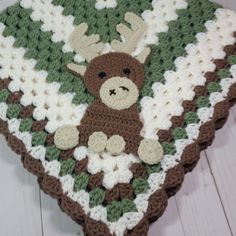 a crocheted blanket with a stuffed animal on it