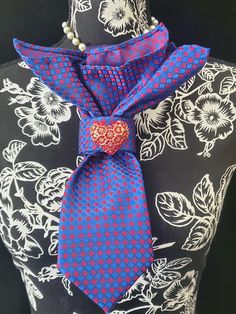 This Blue and Red  Necktie Necklace is made with a (Barry Wang) woven silk tie, and features a Gold Rhinestone Heart Brooch strung on your choice of an adjustable Rosary Chain Ribbon Tie Pearl Necklace or an adjustable Elastic Band. The soft, comfortable fabric sits perfectly on any size chest, while the adjustable necklace feature allows you to customize the fit to your liking. Measuring at a versatile length, this necktie necklace is designed to be a one-size-fits-all. View all Women Tie's: https://www.etsy.com/shop/FearlessAccessorizer?ref=seller-platform-mcnav§ion_id=49097355 The single strand of pearls is an easy and fashionable way to wear this tie necklace. Looks really cute on a t-shirt or a blouse. All jewelry is individually handmade solely by me the designer and owner of Fearles