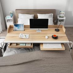 a bed with a wooden desk and computer on it