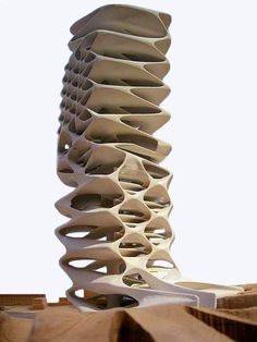 a tall white sculpture sitting on top of a pile of wooden blocks in front of a sky background