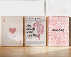 three framed posters with pink and white designs on them, one is for women's day