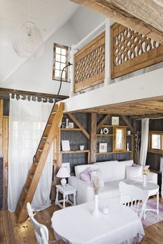 a living room filled with white furniture and wooden floors