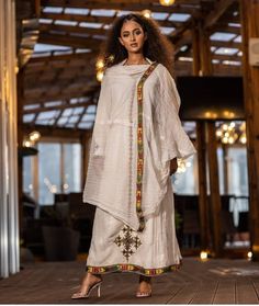 This stunning Ethiopian Habesha dress is made with handwoven Menen fabric, known for its luxurious feel and traditional craftsmanship. The vibrant colors of the dress, paired with intricate Tilf embroidery at the neckline and wrists, make for a truly eye-catching piece. The dress is designed to be comfortable and flattering, with a flowing skirt and flattering waistline. Perfect for any special occasion, this dress is a true testament to the beauty and richness of Ethiopian fashion. PLEASE ADD Y Traditional Raw Silk Kaftan For Designer Wear, Designer Slub Silk Dress With Chikankari Embroidery, Designer Dresses With Chikankari Embroidery, Bohemian Cotton Silk Sets For Spring/fall, Traditional Designer Festive Kaftan, Traditional Designer Kaftan For Festive Occasions, Traditional Cotton Silk Kaftan For Festivals, Traditional Chanderi Kaftan With Dupatta, Bohemian Chanderi Kurta For Designer Wear