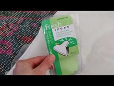 someone is holding a green and white eraser in their left hand, with the packaging on