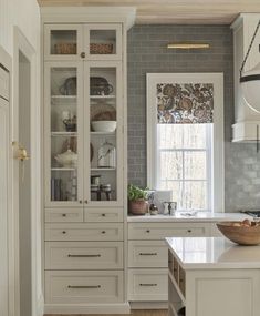 a large kitchen with white cabinets and drawers