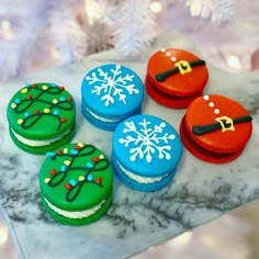 four decorated cookies sitting on top of a marble counter