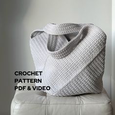 a crochet bag sitting on top of a white leather bench