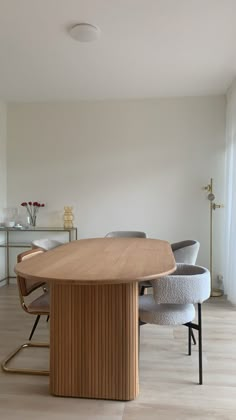 an oval wooden table with chairs around it