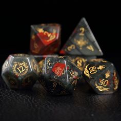 several different colored dice with gold designs on them