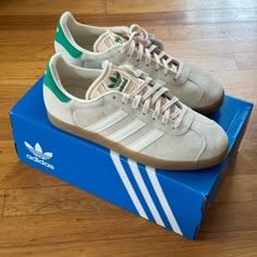 The Adidas Women's Gazelle 'Wonder White Green' Is Built With Off-White Suede Uppers, Featuring Cream-Colored Serrated Leather Three-Stripes And A Leather Back Tab In Kelly Green. The Verdant Hue Is Repeated On The Embossed Trefoil Logo That Adorns The Molded Tongue. Anchoring The Low-Profile Silhouette Is A Semi-Translucent Gum Rubber Cupsole. Wonder White Green 2023 Colorway. Sold Out Online. Wonder White/Cream White/Gum Us Size 8 Womens Obsessed With These But Just Slightly Too Small For Me. Adidas Nmd White, Adidas Gazelle White, Adidas Samba Women, Nmd Adidas Women, Snicker Shoes, Adidas Originals Shoes, Adidas Shoes Originals, Bold Shoes, Adidas Handball Spezial