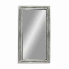 a silver framed mirror on a white wall