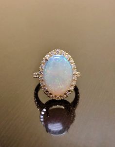 an opal and diamond ring sits on a table