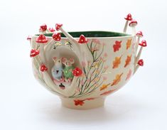 two mice in a teacup with red mushrooms on the sides and green rims