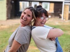 two women hugging each other in front of a house