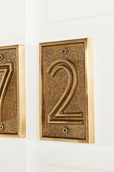 two gold numbers are on the wall next to each other