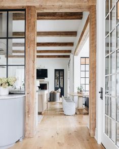 the interior of a house with white walls and wood beams on the ceiling is featured in this magazine