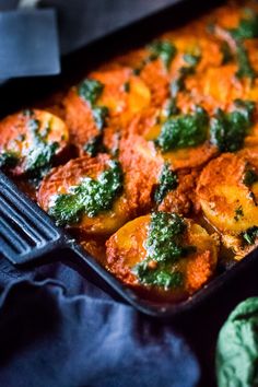 a casserole dish with broccoli, cheese and sauce in it on a table