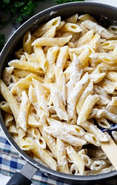 a pan full of pasta with chicken and parsley on the side, ready to be cooked