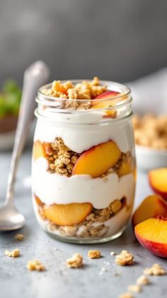 a glass jar filled with yogurt and peaches on top of a table