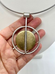 Modern pendant. Silver and gold metal. Not sterling. Gold Brass Modernist Jewelry, Modernist Gold Brass Jewelry, Modernist Gold Metal Jewelry, Modern Bronze Metal Necklace, Modern Bronze Metal Necklaces, Modern Metal Oval Pendant Jewelry, Modern Metal Jewelry With Oval Pendant, Modern Silver Brass Necklace, Modernist Gold Sterling Silver Jewelry