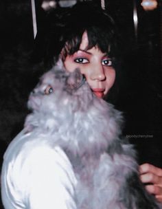 a woman is holding a cat in her arms and posing for the camera with it's mouth open