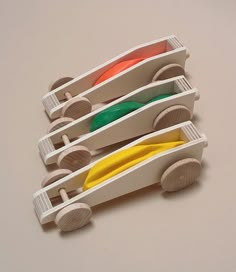 four wooden toy cars stacked on top of each other with different colored discs in them