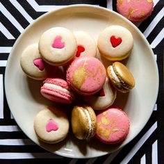 a white plate topped with pink and gold macaroons