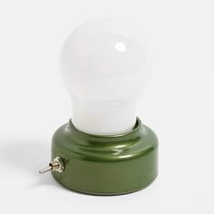 a white light bulb sitting on top of a green stand