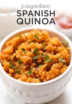 a white bowl filled with spanish quinoa on top of a marble countertop