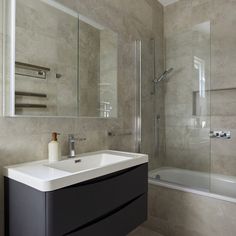 a bathroom with a sink, mirror and bathtub next to the shower stall is shown