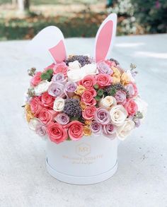 a white box filled with flowers and bunny ears