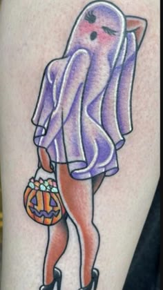 a woman's thigh with an octopus holding a pumpkin in her right hand and wearing high heeled shoes